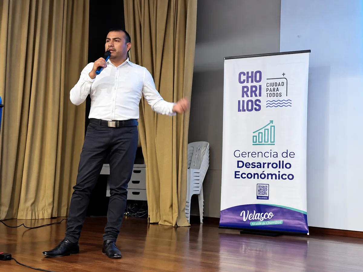 Leoncio Vilchez exponiendo junto a un panel de conferencia